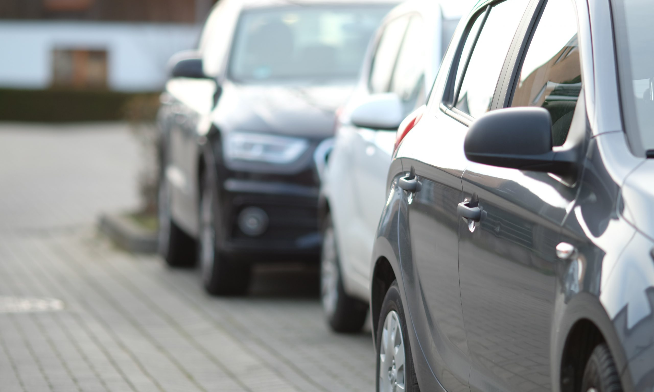 closeup-shot-black-car-parking-lot-with-blurred-background-scaled.jpg