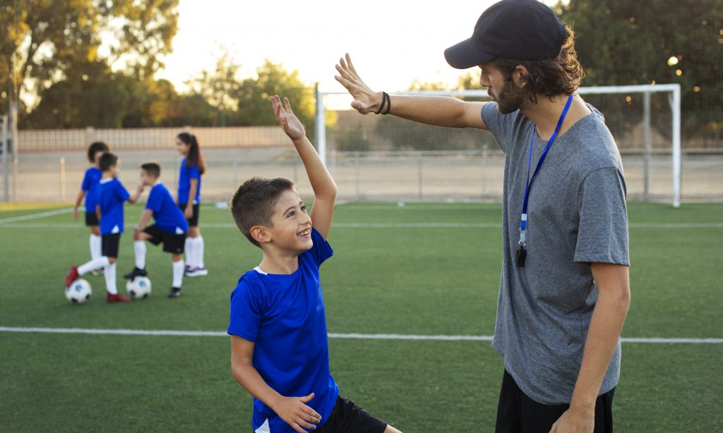 entrenador-futbol-felicitando-vista-lateral-nino-1024x683-1.jpeg